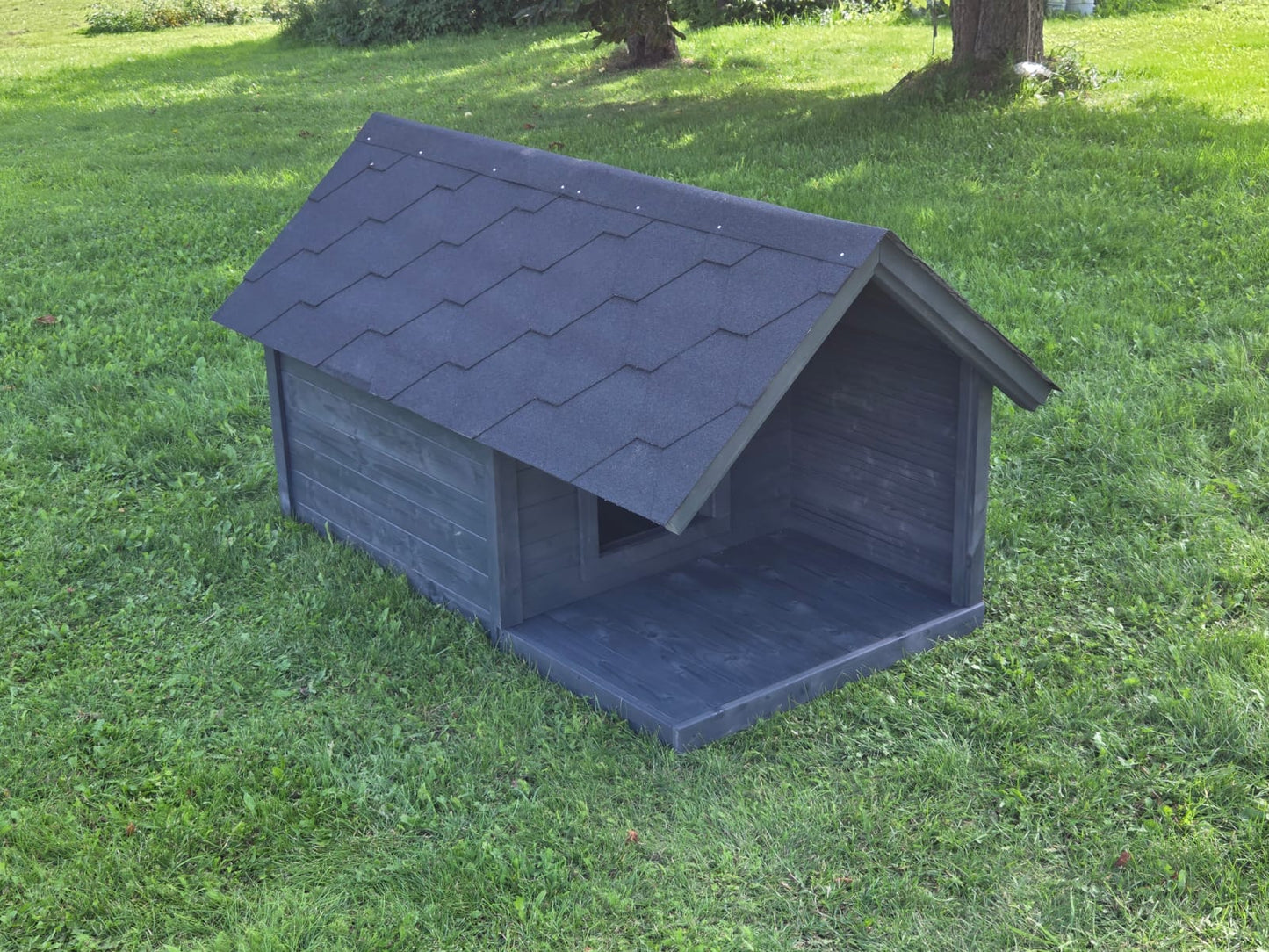 Dark gray dog house on a grassy lawn