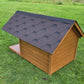 Wooden doghouse with a black roof on a grassy field