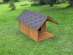 Wooden dog house with a gray roof on a grassy lawn