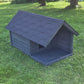 Dark gray dog house on a grassy lawn