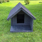 Gray dog house on a grassy field