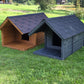 Two wooden dog houses, one brown and one gray, on a grassy field.
