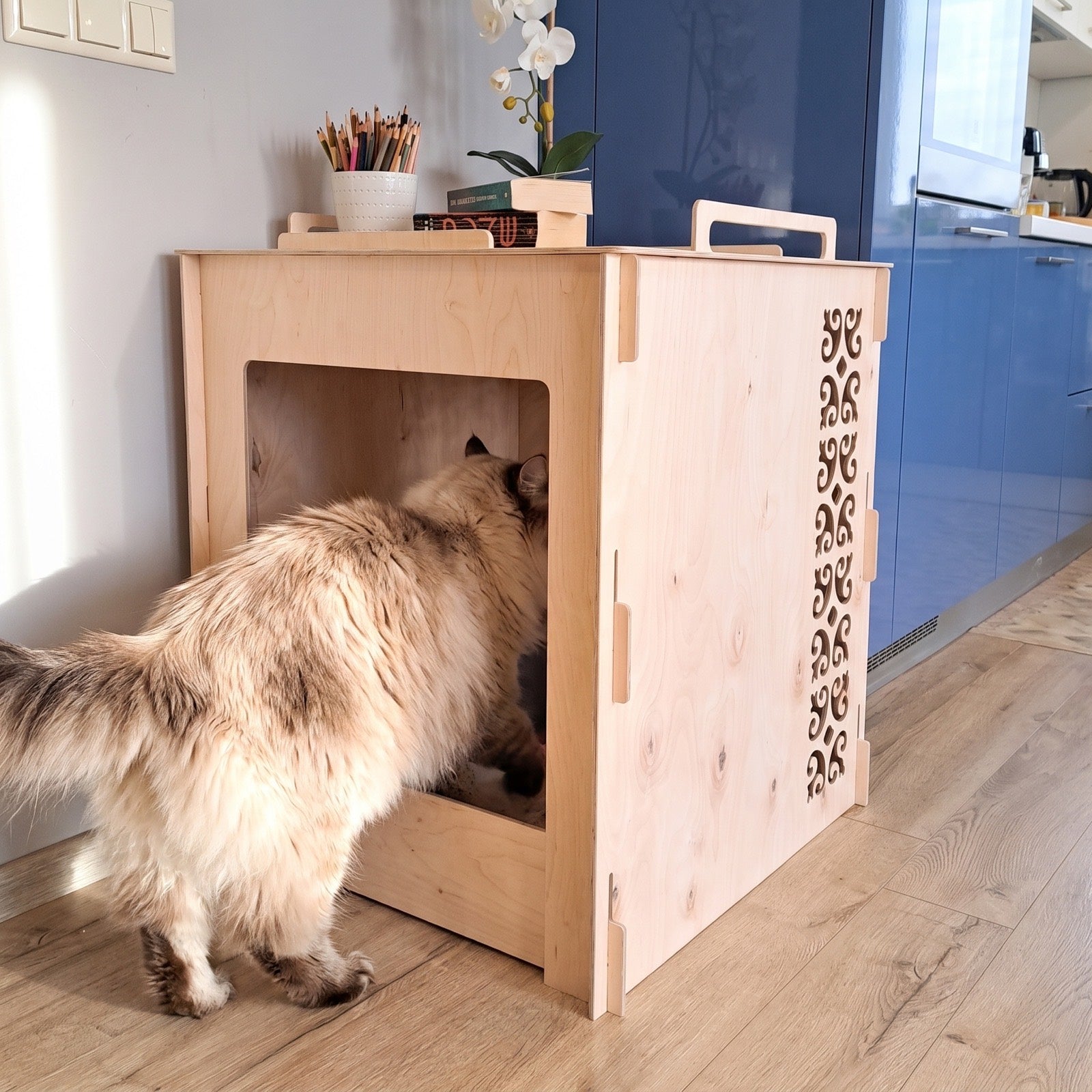 A cat stepping into the arched entrance of the birch cover - open and comfortable, cats use it right away.