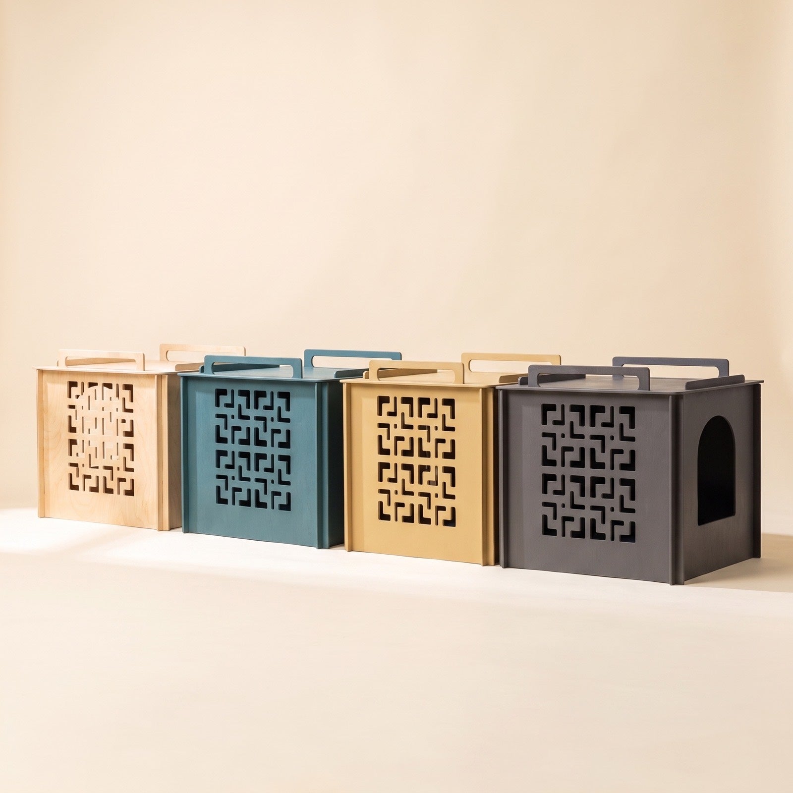 The cover in four finishes: natural birch, dark teal, sand yellow and rich gray, each with the laser-cut panel.
