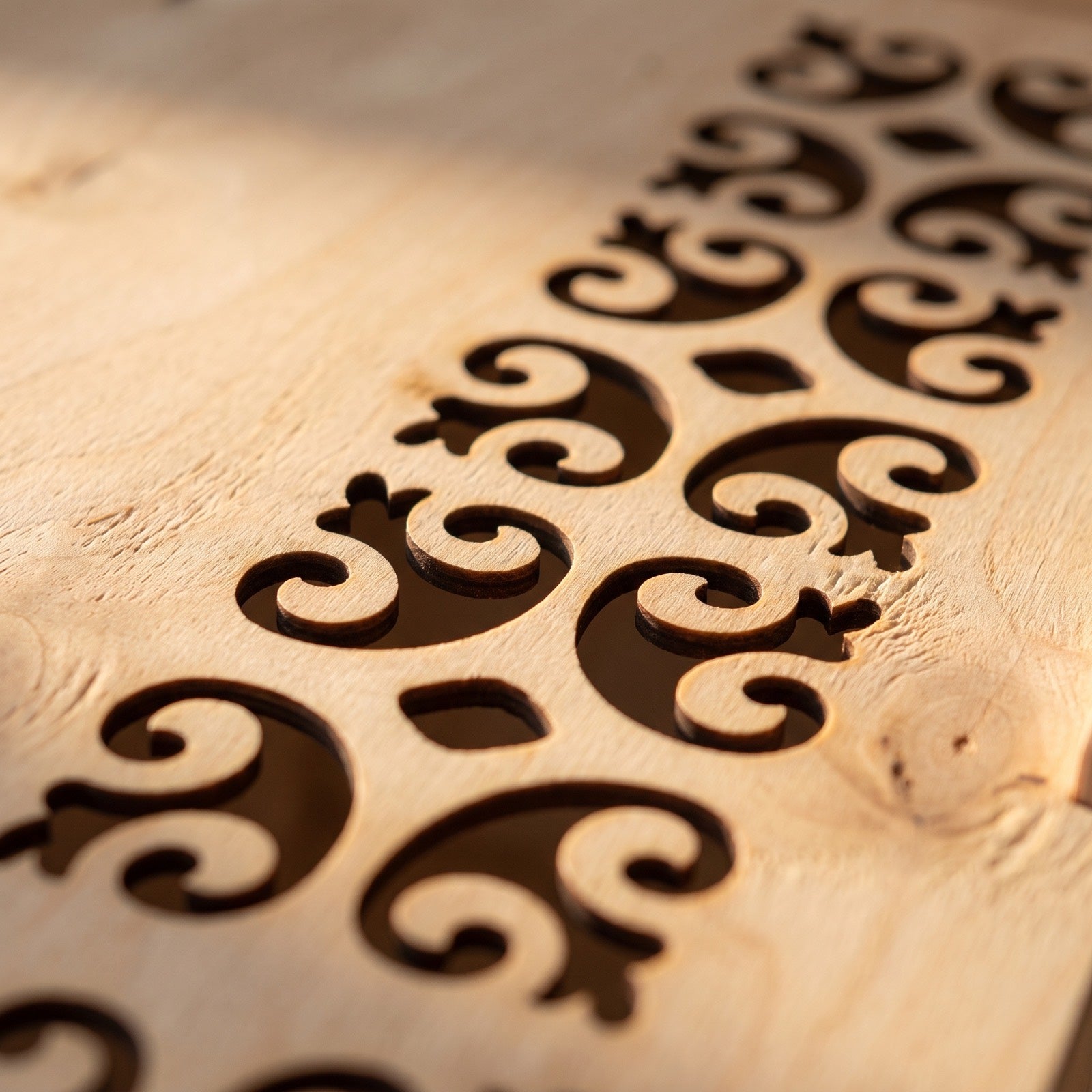Close-up of the ornamental laser-cut panel on real birch plywood - our own registered design, cut in our European workshop.